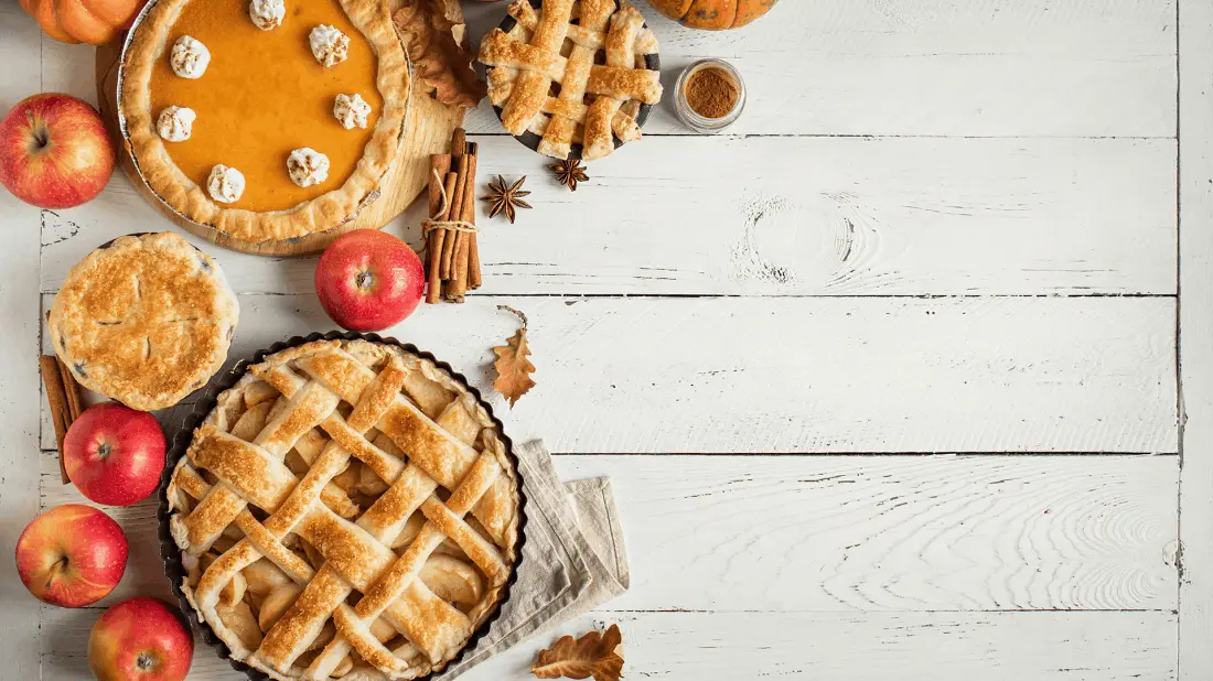 pumpkin and apple pie on a white wooden table