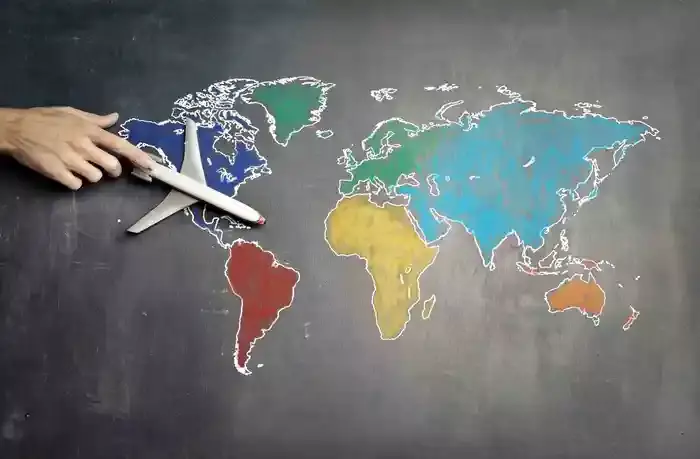 toy airplane on a chalk board tha shows a world map
