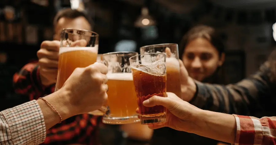 Oktoberfest attendees make a toast, clanging their beer glasses together