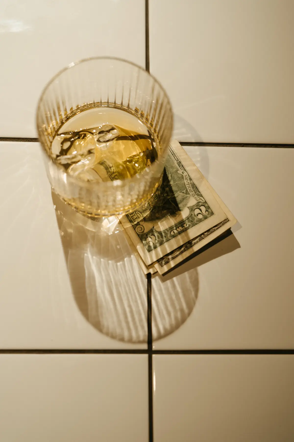 two dollar bill under a highball glass