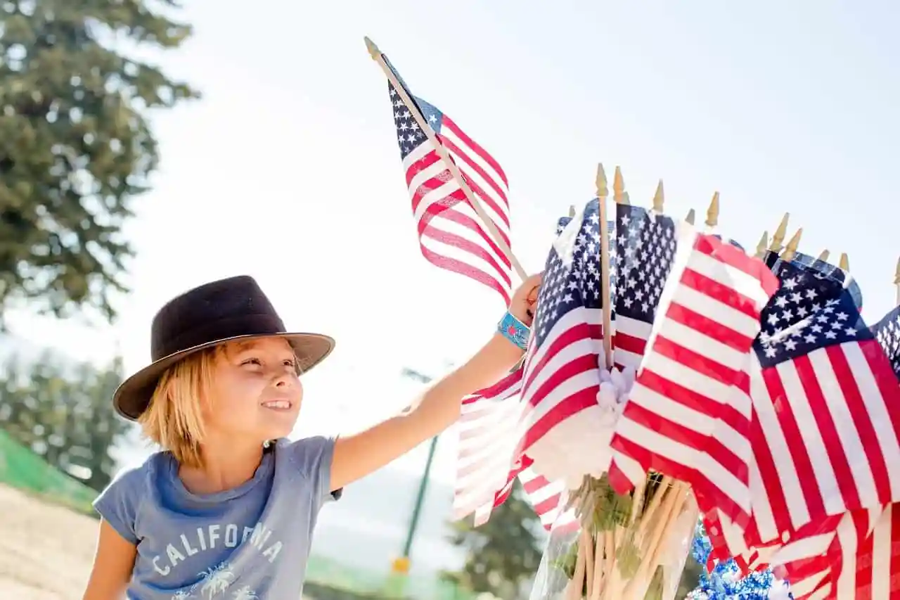 boy next to a bouquet of small American flags