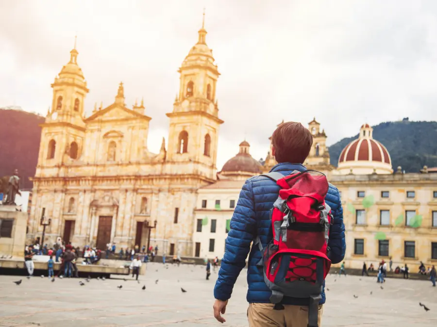 A man wears his travel backpack while walking near the Plaza De Bolivar in Bogota, Colombia