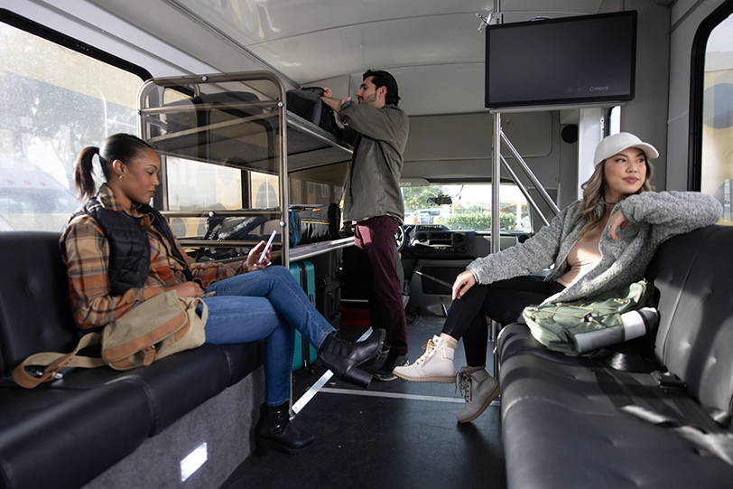 Three off-site airport parkers inside an airport shuttle.