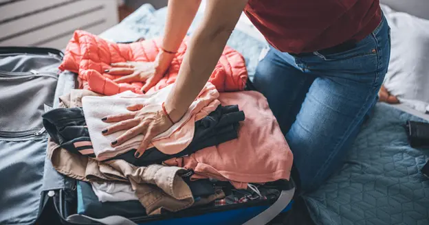 An airline passenger packs her bag before going to the airport.