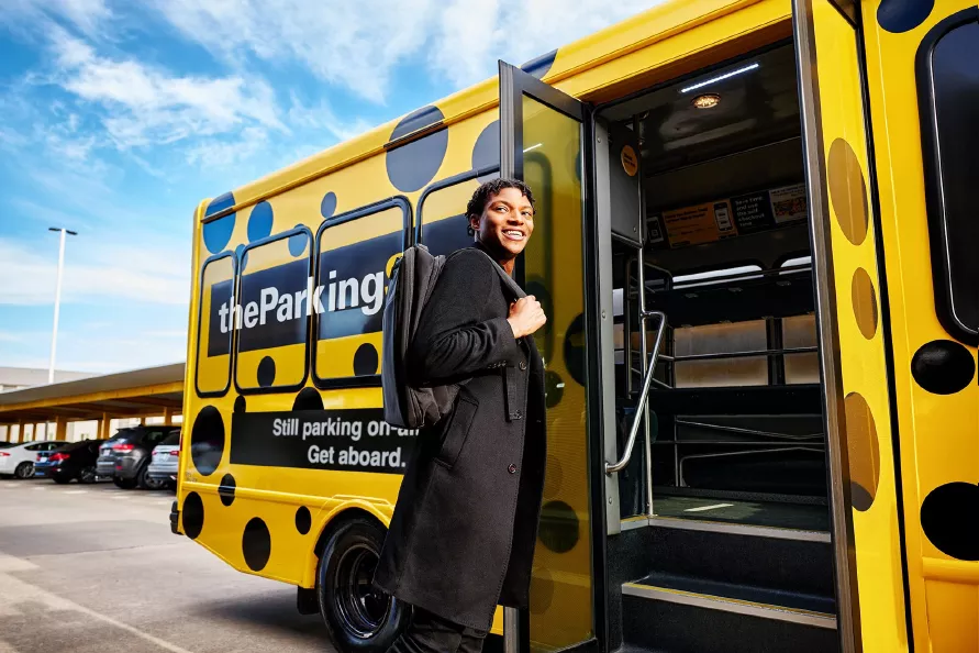 A guest of The Parking Spot boards a free airport shuttle to the terminal