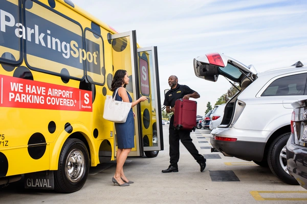 shuttle driver moves luggage from vehicle to shuttle